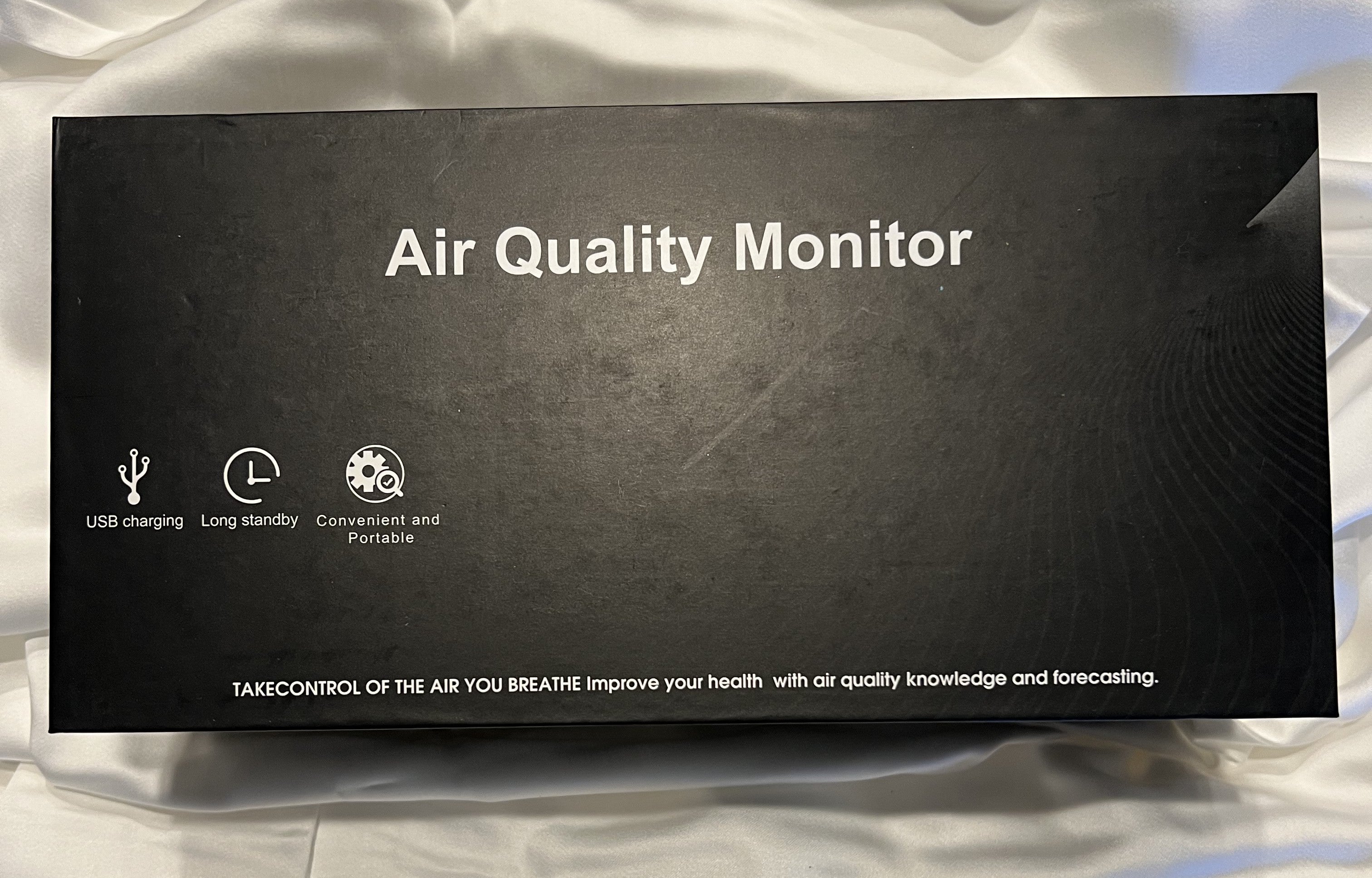 Digital 9 in 1 air quality monitor with various readings on a white background. pm 2.5, CO2, and Radon Monitoring. USB Cable on black box. Monitor your IAQA at home or in the workplace with this portable device.