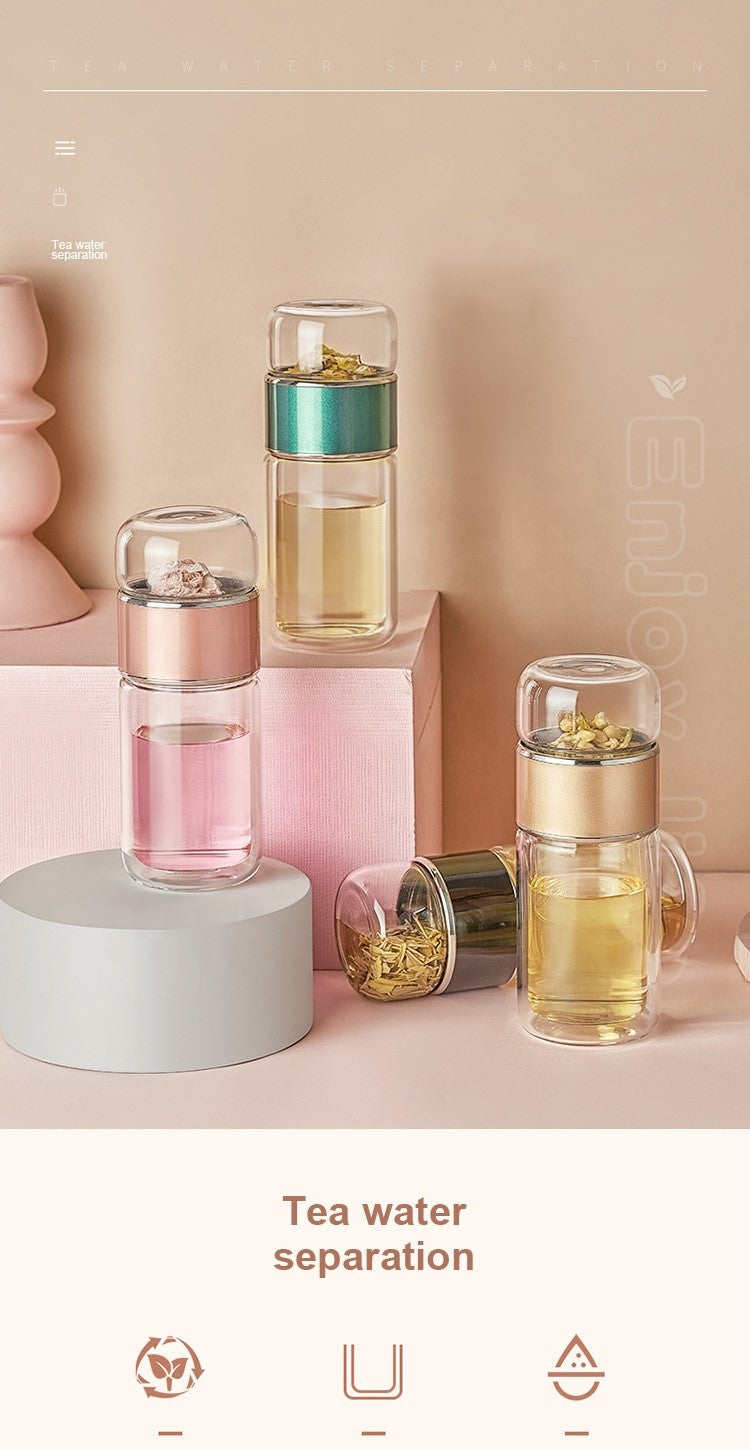 A set of elegant glass tea infuser drinkware with stainless steel infusers, displayed in pink, blue, and clear colors. They are shown with a separation feature for tea water. From Well Building Connection