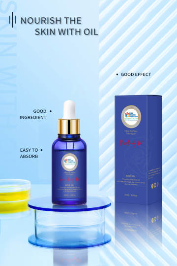 A bottle of Wellness Oil from Well Building Connection– Rose & Lavender on a clear surface with its packaging box in the background, featuring a blue and white color scheme.