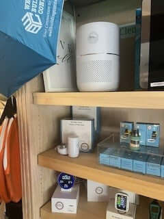 White Hepa Air Purifier with Well Building Connection Logo. A white cylindrical HEPA air purifier with a perforated lower section and a Well Building Connection logo on the front. Indoor Air Pollutants too many to list and everyone benefits from this air purifier from Well Building Connection.